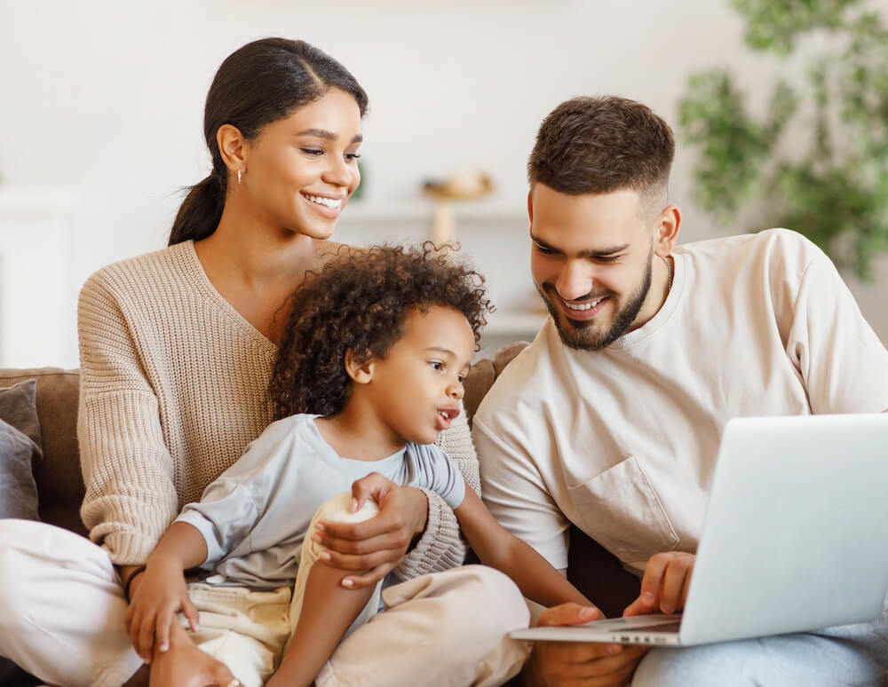 family on couch looking at laptop